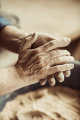 Close up of male potter hands taking clay from a bowl