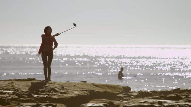 Young woman on a beach is making a selfie