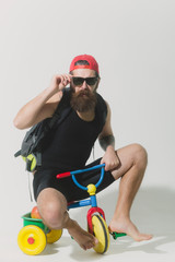 bearded surprised man with bag, apple on bicycle toy