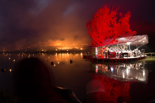 Orchestra on a island playing classical music while forest fire on background