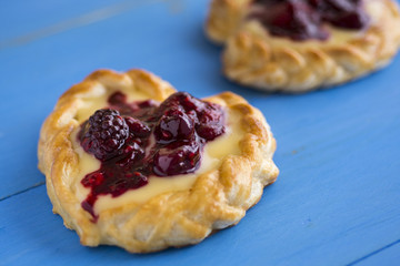 Vanilla Cream and Fruit Berry Puff Pastry Dessert on Blue Background