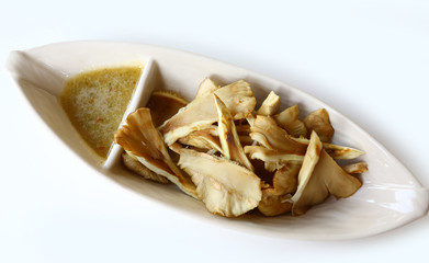 Grilled mushrooms in plate with spicy sauce.