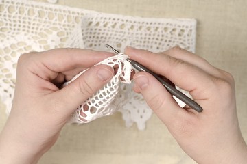 Hands of a woman knit a dress.