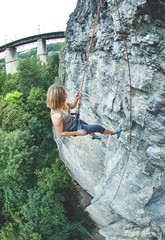 woman rock climber climbs on the cliff. rock climber climbs on a rocky wall. woman descends on a rope down.
