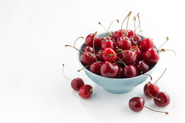 bowl of fresh cherries on a white background, top view