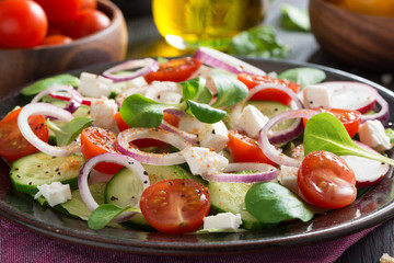 vegetable salad with feta cheese on a plate, close-up, selective focus