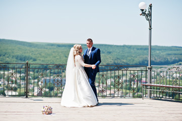 Obraz premium Happy wedding couple in love at observation deck on sunny day.