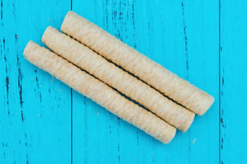 top view sweet egg rolls on blue wood