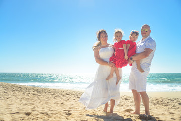 Happy family hugging on the beach