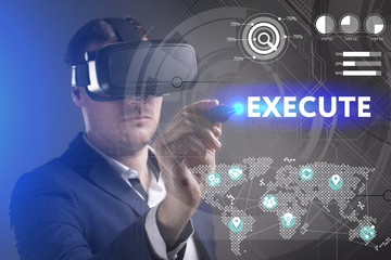 Business, Technology, Internet and network concept. Young businessman working in virtual reality glasses sees the inscription: Execute