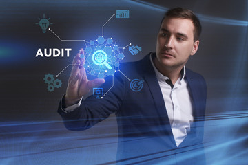 Business, Technology, Internet and network concept. Young businessman working on a virtual screen of the future and sees the inscription: Audit