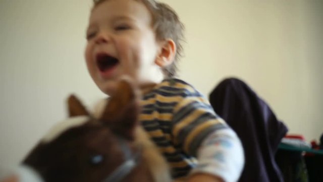 Cute, little boy sitting on the rocking horse and having fun
