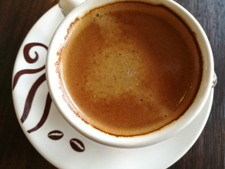 Cup of hot espresso coffee on wooden table