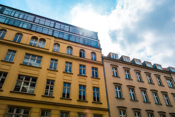 typical apartment houses at Berlin with orange facade and small sunlight on the top