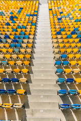 Obraz premium rows of yellow and blue stadium seats and stadium stairs