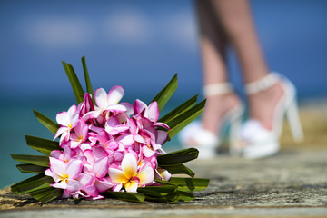 Accessory kit for a wedding bridal bouquet with pink orchid is on the pier near coastline of caribbean sea
