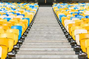Naklejka premium rows of yellow and blue stadium seats and stadium stairs