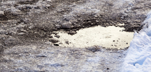 Snow with puddles on the road