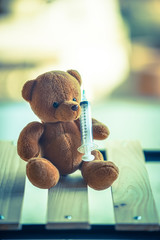 bear doll and syringe with cold tone