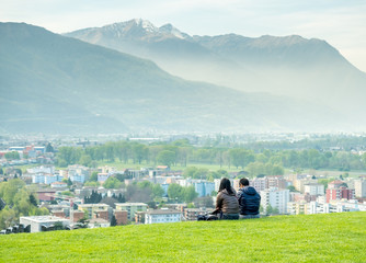 Two people sit on green grass