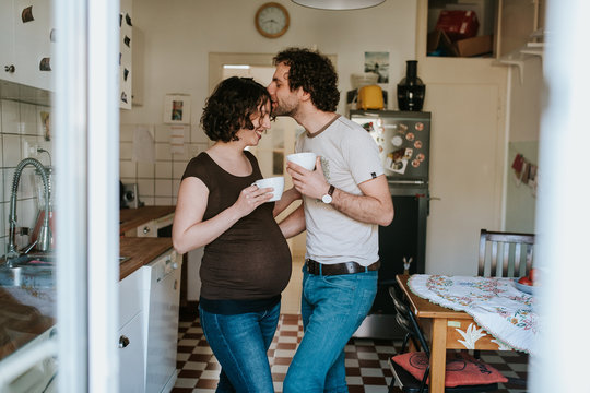 pregnant couple drinking tea in the kitchen