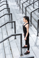 Side view of sporty young woman exercising on stadium stairs