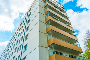 white plattenbau building with orange balconies