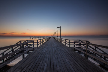 Fototapeta na wymiar Wooden pier in Mechelinki. Small fishing village in Poland. Amazing Sunrise at the beach