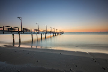 Wooden pier in Mechelinki. Small fishing village in Poland. Amazing Sunrise at the beach