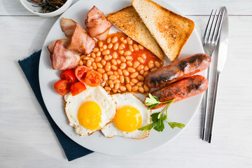 Full english breakfast served on white wooden table. Closeup. Top view