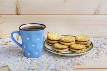cup of coffee with biscuits on a wooden background