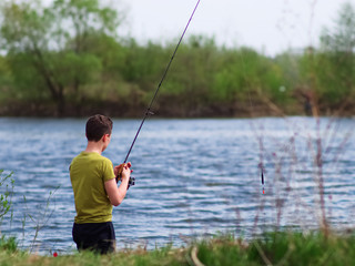Teenager catches fish on the river