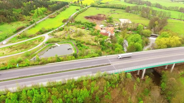 Aerial view of bridge over Radbuza River and green pastures. Highway D5 with traffic near Pilsen, Czech republic, Central Europe. Transportation and sustainable development concept. 