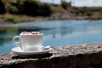 Чашка кофе на фоне реки .
