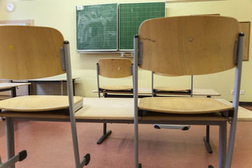 Leerer Klassenraum mit hochgestellten Stühlen