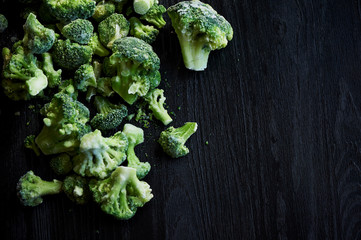 Frozen broccoli on a black wooden background . Vegetarian lifestyle, healthy eating