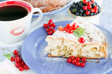 piece of sweet cake with red currants and coffee