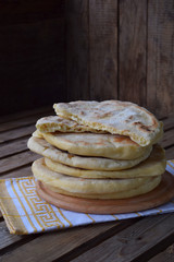 Pile of homemade flat bread on a wooden background. Mexican flatbread taco. Indian Naan. Space for text
