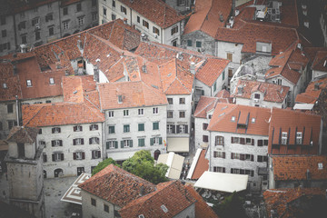 Fototapeta na wymiar Bright tiled roofs of the houses in Kotor old town in Montenegro seen from above