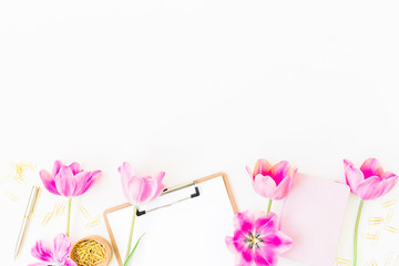 Beauty blog concept. Workspace with clipboard, notebook, pen, pink tulip flowers and accessories on white background. Flat lay, top view. Blogger or freelance