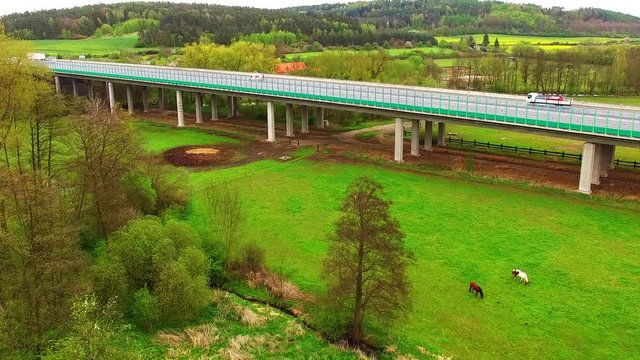 Aerial view of bridge over Radbuza River and green pastures. Highway D5 with traffic near Pilsen, Czech republic, Central Europe. Transportation and sustainable development concept. 