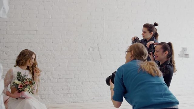 Photographers in the master class photograph the bride in the style of a boho. In the photo studio.