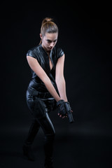 Fototapeta na wymiar Superhero police woman in a leather catsuit with guns