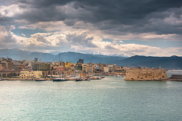 Fototapeta na wymiar Neoria, old venetian walls of the shipyards at Heraklion with the port and the castle of koule, Crete, Greece.