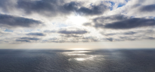 Breakthrough of light in clouds over a calm sea