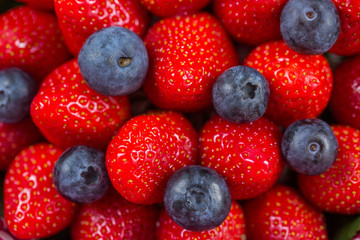 Obraz premium Background of fresh strawberries and blueberries. Close-up