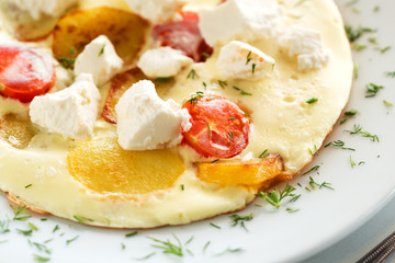 Delicious omelette with tomato, potato and goat cheese
