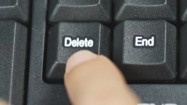 Close up of human finger pushing an delete button on the computer keyboard