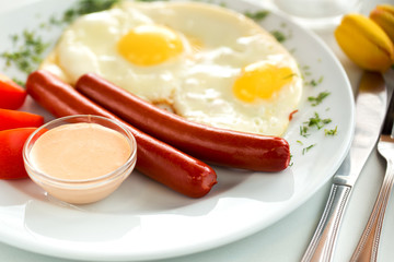 Tasty breakfast sausages and fried eggs