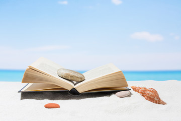 Book on the beach with white sand